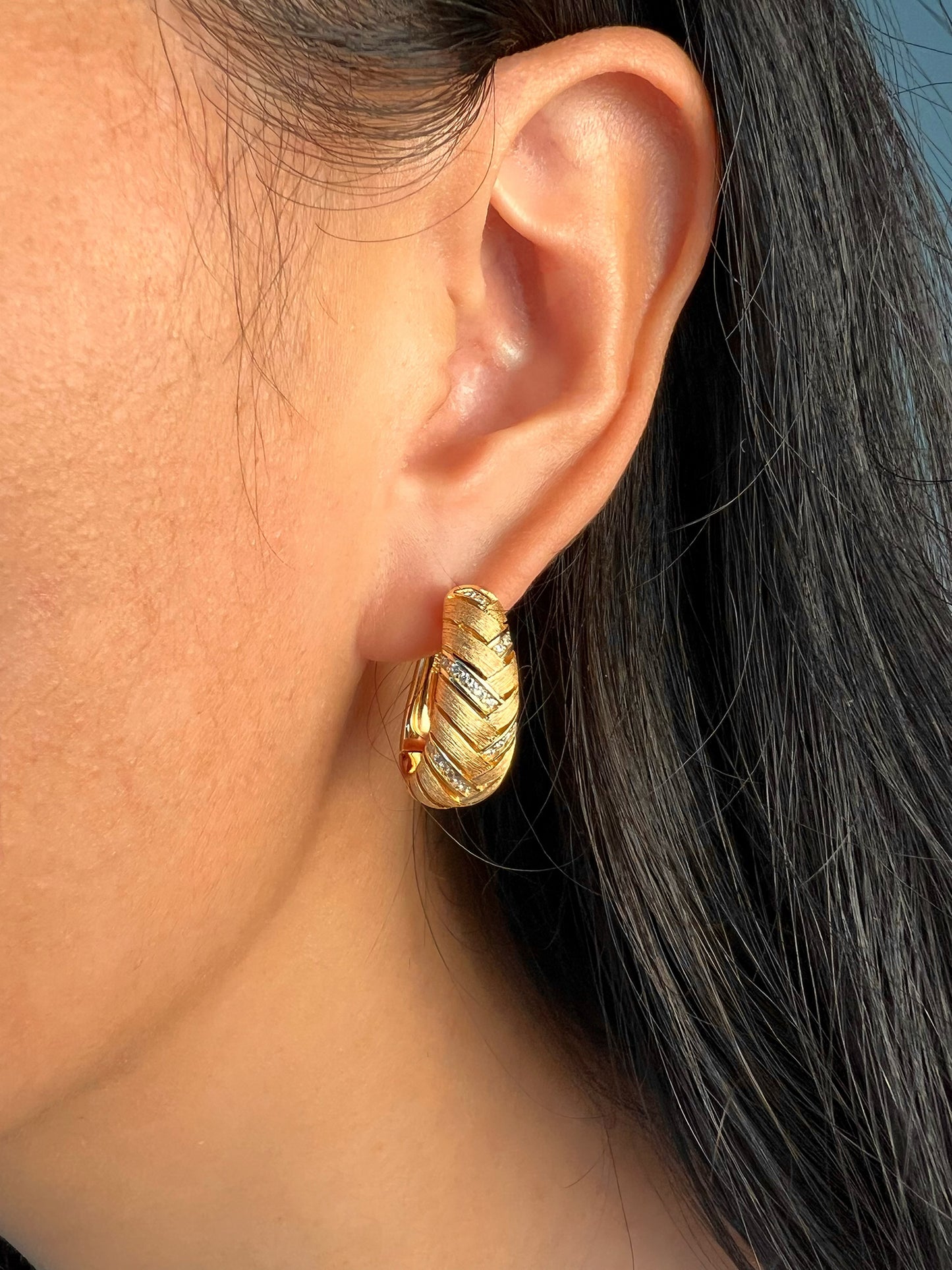 Model showcasing the elegant woven golden earrings, adding a touch of sophistication to any ensemble.