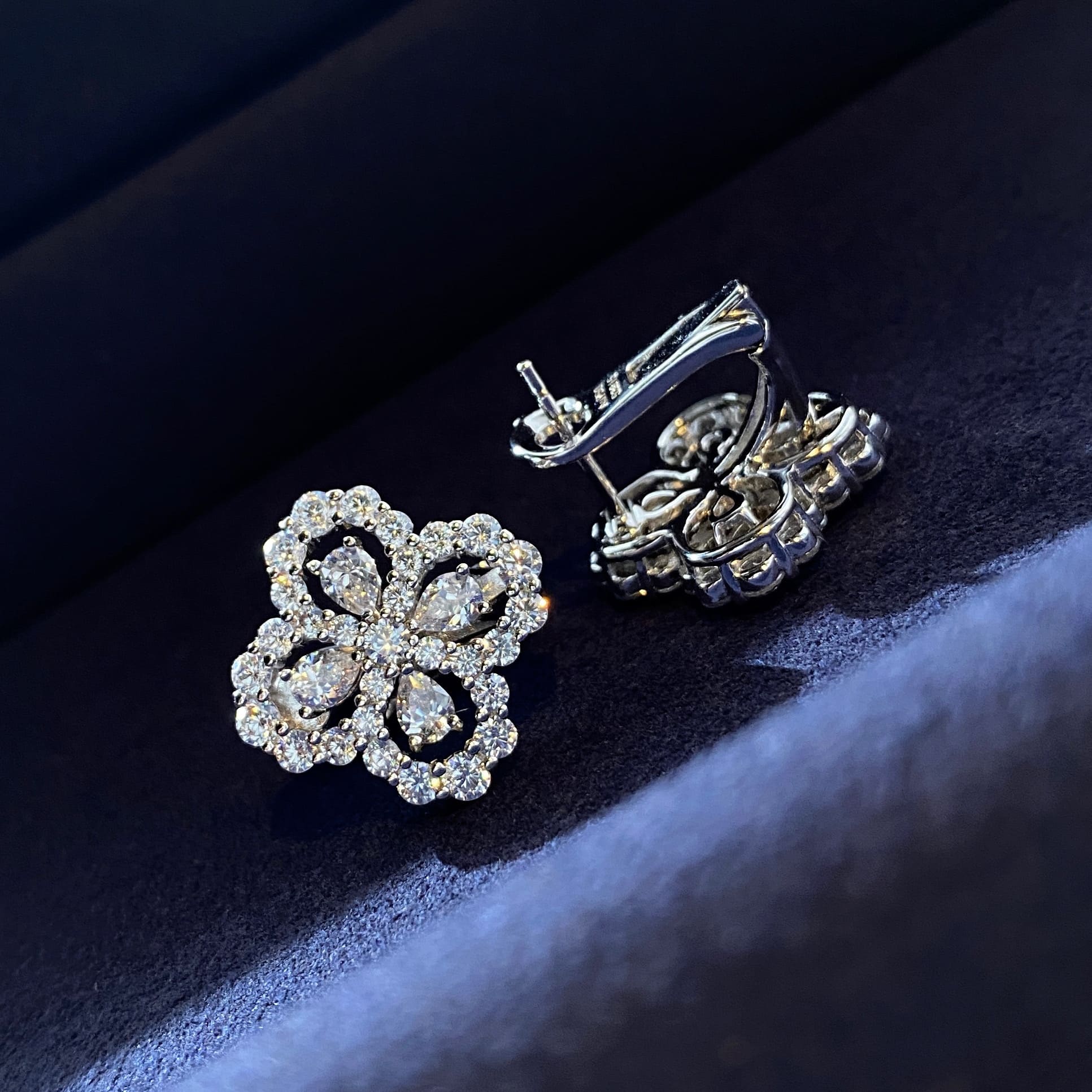 Stunning Clover Stud Earrings on a Blue Background, featuring captivating cubic zirconia embellishments.