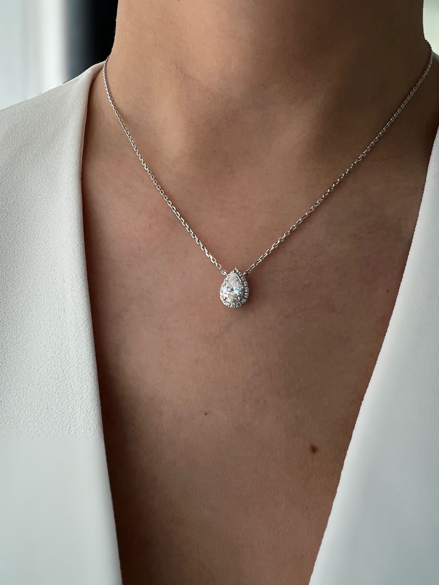 1.5 Carat pear-shaped cubic zirconia pendant necklace with a hidden halo setting on a delicate chain.