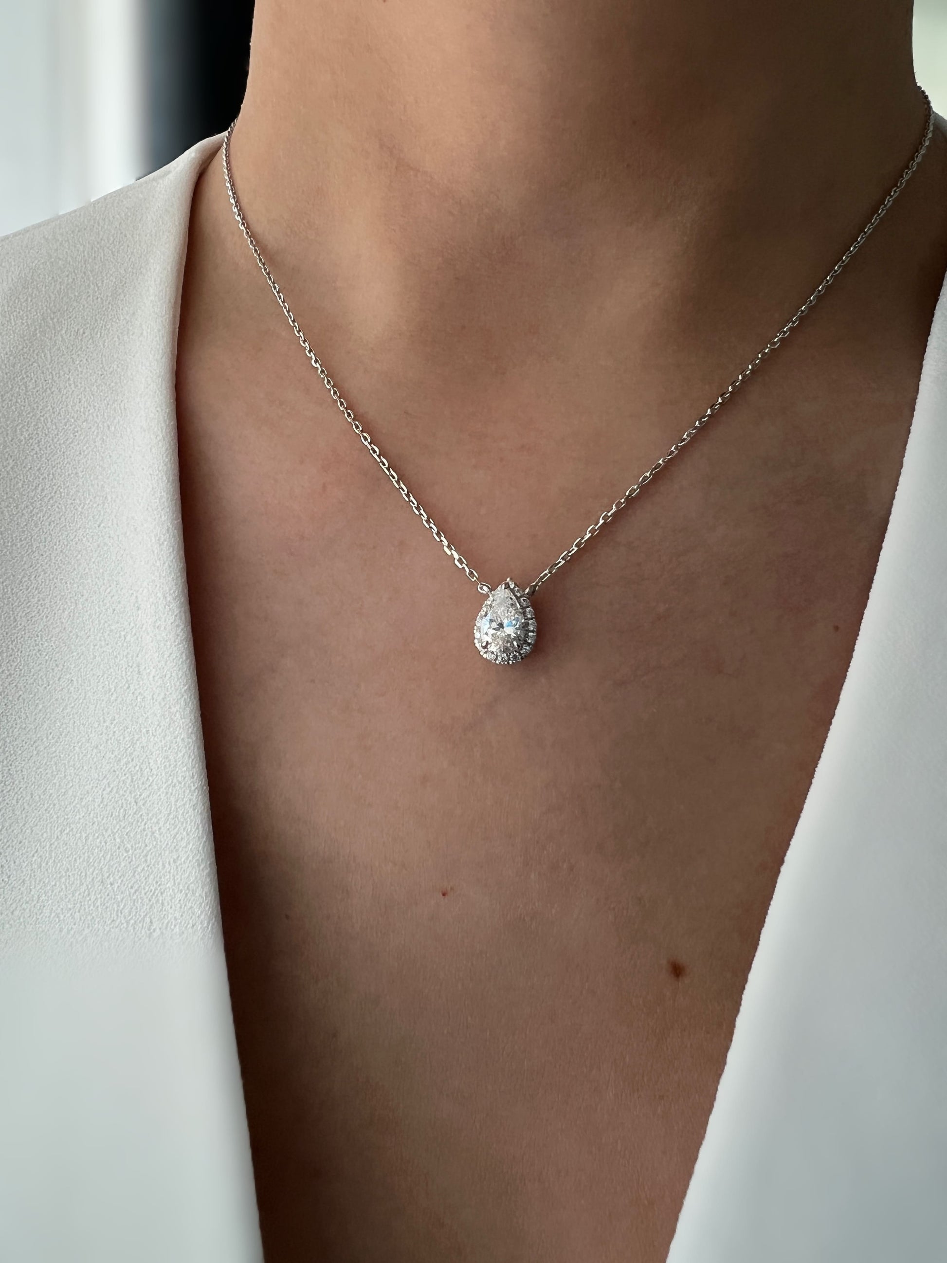 1.5 Carat pear-shaped cubic zirconia pendant necklace with a hidden halo setting on a delicate chain.