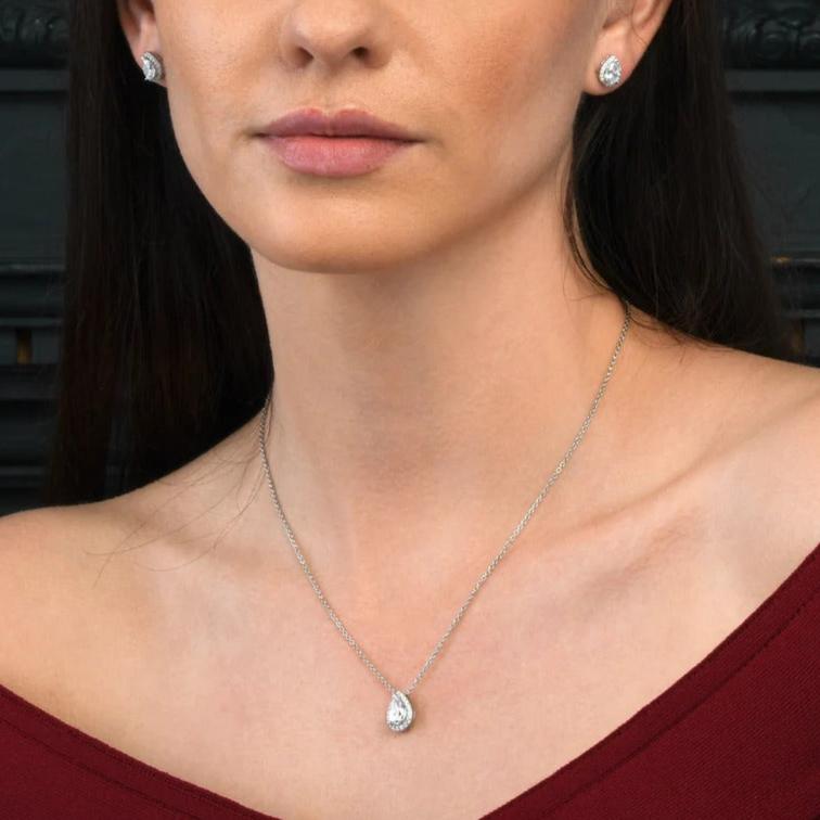 Model wearing a 1.5 carat pear-shaped cubic zirconia pendant necklace with hidden halo setting, showing the necklace's elegant drop on the chest.